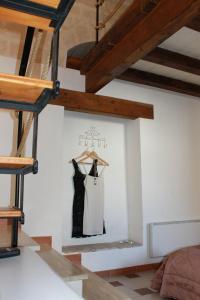 モンテスカリオーゾにあるCasa vacanza L'antico fontaninoの黒いドレスが部屋の壁に掛けられている