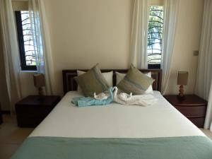 a bedroom with a bed with towels on it at Anaya Résidence in Flic-en-Flac