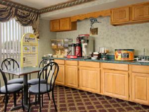a kitchen with wooden cabinets and a table and chairs at Days Inn by Wyndham Jacksonville in Jacksonville
