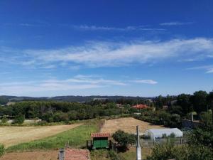 un campo vacío con una granja en la distancia en Arzúa Home en Arzúa