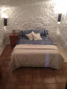 1 dormitorio con 1 cama con 2 almohadas en Cueva Chelaja, en Galera