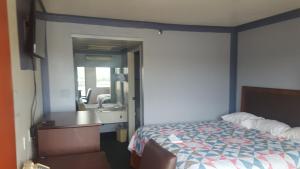 a bedroom with a bed and a sink and a mirror at Travel Inn in Sharonville