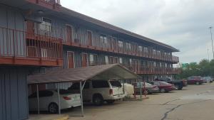 a building with cars parked in a parking lot at Travel Inn in Sharonville