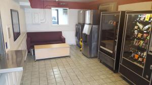 eine Küche mit einem Kühlschrank, einem Sofa und einem Tisch in der Unterkunft Travel Inn in Sharonville