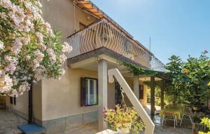a house with a staircase leading to a patio with flowers at APARTMANI SANDRA PRPIĆ in Rab