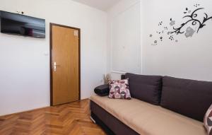 a living room with a couch and a door at APARTMANI SANDRA PRPIĆ in Rab