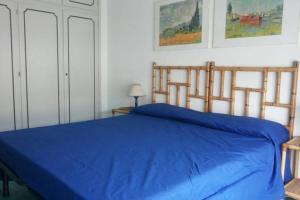 カスティリオーネ・デッラ・ペスカーイアにあるAppartamento l'Approdoのベッドルーム1室(青いベッド1台、木製ヘッドボード付)