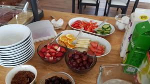 a table with bowls of fruit and plates on it at Hafdals Hotel in Akureyri