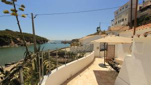 a balcony with a view of the water at Chalé da Baía in Porto Covo