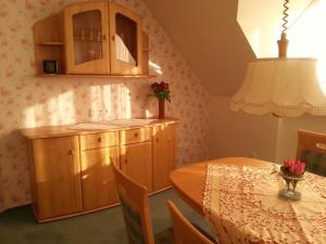 a kitchen and dining room with a table and cabinets at Ferienwohnung Ostfriesenglück in Leer +37 photos