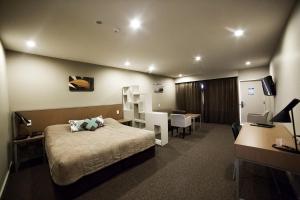 ein Hotelzimmer mit einem Bett und einem Schreibtisch in der Unterkunft Northstar Motel in Oamaru