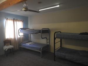 a room with three bunk beds and a window at Kalbarri Backpackers YHA in Kalbarri
