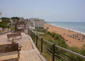 a beach with benches and umbrellas and the ocean at Vila Branca in Mosqueira