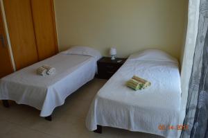 two beds in a hotel room with white sheets at Vila Branca in Mosqueira +42 photos