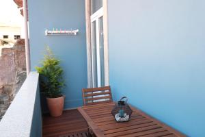 uma varanda com uma mesa de madeira e uma parede azul em Porto Duke's House no Porto