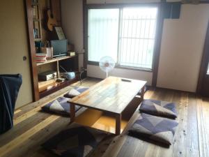 uma sala de estar com uma mesa de centro e uma ventoinha em Fujiya em Matsuyama
