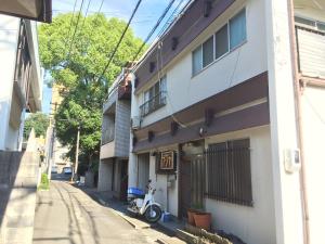 uma moto estacionada ao lado de um edifício numa rua em Fujiya em Matsuyama
