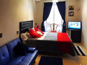 sypialnia z łóżkiem, kanapą i telewizorem w obiekcie BOOKINGHAM ★Apartaments & Suites w Madrycie