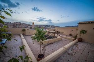 a rooftop balcony with a view of a city at Riad Gzira Fez in Fès
