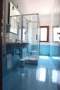 a blue bathroom with a shower and a sink at Casale degli Ulivi Resort in Pellare