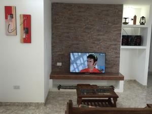 - un salon avec une télévision et un mur en briques dans l'établissement Casa Patagónica Los Frutales, à El Calafate 14 autres photos