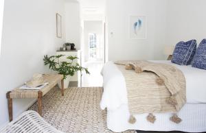 
a bed room with a white bedspread and pillows at Satara Byron Bay in Byron Bay
