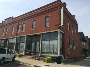 a red brick building with a white car parked in front at The Courtland Hotel & Spa in Fort Scott