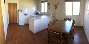 a kitchen and dining room with a table and a refrigerator at Black Jack Get-A-Way "Magpies Nest" in Orroroo