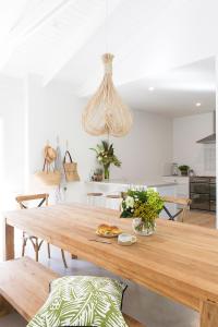 a dining room with a wooden table in a kitchen at Satara Byron Bay - Adults Only in Byron Bay