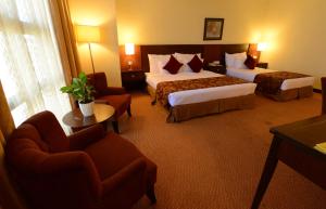 The Grand Puteri Hotel tesisinde bir odada yatak veya yataklar