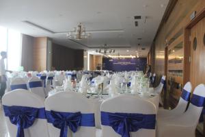 a room with a table with white chairs and blue bows at Muong Thanh Cua Dong Hotel in Vinh