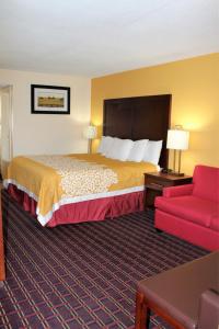 a hotel room with a bed and a red couch at Bluegrass Inn in Frankfort