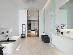ein weißes Badezimmer mit einem Waschbecken und einem Schreibtisch in der Unterkunft Malaiwana Residences in Nai Thon Beach