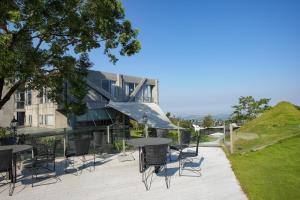 a patio with tables and chairs in front of a building at Khokak Panoramas Hotel in Gukeng