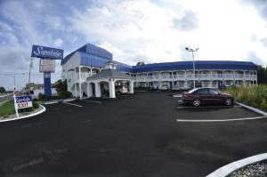 un grande edificio con un'auto parcheggiata in un parcheggio di Superlodge Absecon/Atlantic City ad Absecon
