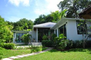 una casa blanca con un jardín delante de ella en Samui Honey Tara Villa Residence en Choeng Mon Beach