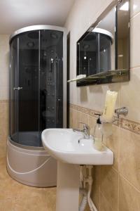a bathroom with a sink and a shower at Fedorov ApartHotel Barnaul in Barnaul