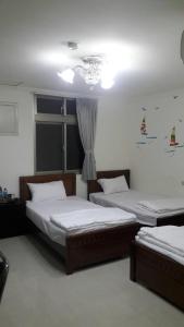 a bedroom with two beds and a chandelier at Home run Homestay in Dongyin