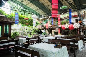a restaurant with tables and chairs in a building at Mountain View GuesthouseChiangmai in Chiang Mai