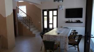 a dining room with a table and chairs and a television at Casa Fulg de Nea in Moieciu de Sus