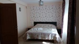 a bedroom with a bed with a floral wallpaper at Casa Fulg de Nea in Moieciu de Sus