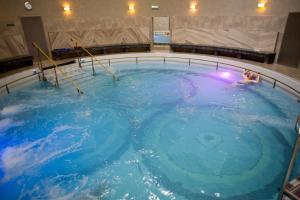 a woman swimming in a large pool of blue water at Uzdrowisko Cieplice - Jelenia Góra - Długi Dom in Jelenia Góra