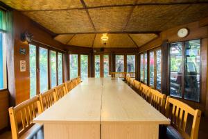 a long wooden table in a room with chairs at Mountain View GuesthouseChiangmai in Chiang Mai