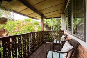 a porch with a table and chairs on it at Mountain View GuesthouseChiangmai in Chiang Mai