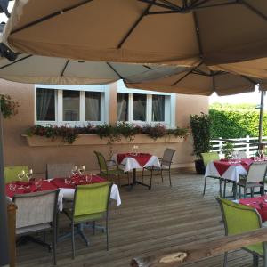 オーソンヌにあるVilla Varcoのテーブル、椅子、パラソルが備わるレストラン