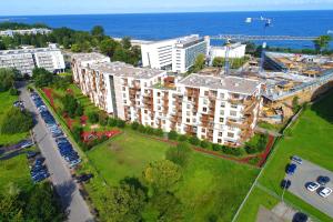 an overhead view of a large building with the ocean in the background at Apartamenty Olympic Park in Kołobrzeg
