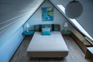 sypialnia z łóżkiem na poddaszu z dwoma stołami w obiekcie Det Gamle Mejeri w mieście Stokkebro