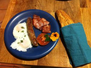 a blue plate with breakfast food on a table at Windrose B&B in Denmark