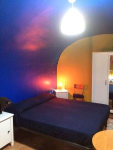 1 dormitorio con 1 cama con una pintura en la pared en Casa Colore, en Nápoles