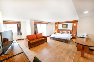 パタヤ・セントラルにあるSiam View Hotel and Residenceのベッドルーム(ベッド1台、ソファ、テレビ付)